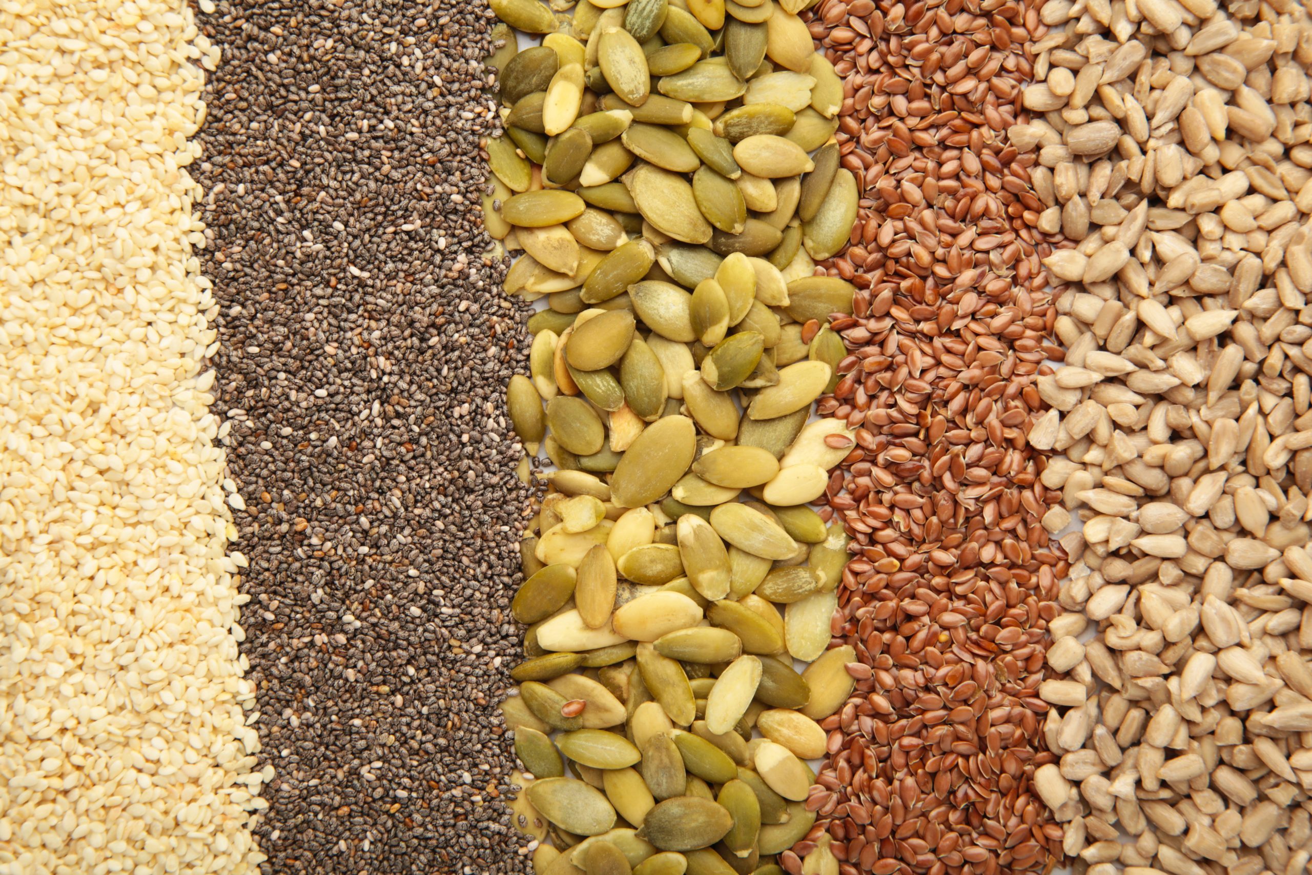 Healthy superfood: sesame, pumpkin seeds, sunflower seeds, flax seeds and chia background. Seeds on spoon. Top view